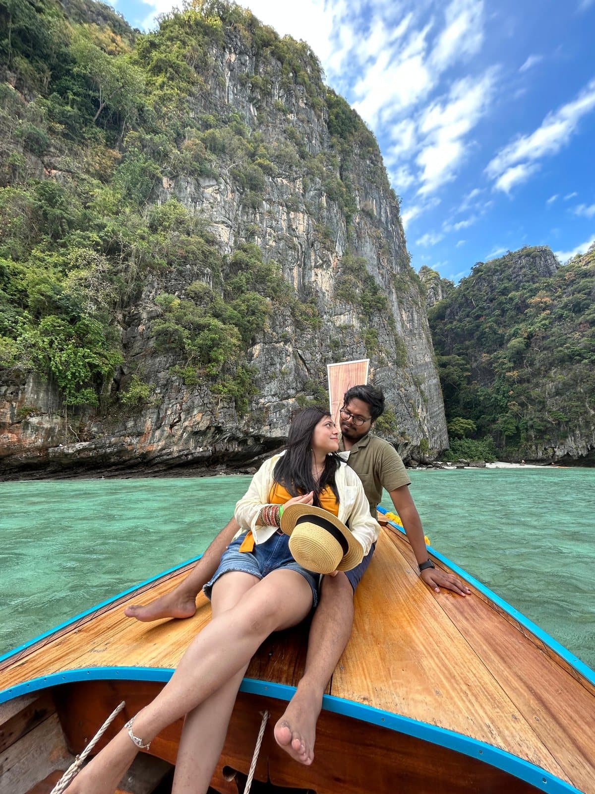 A couple on a longtail boat by the cliffs at Phi Phi